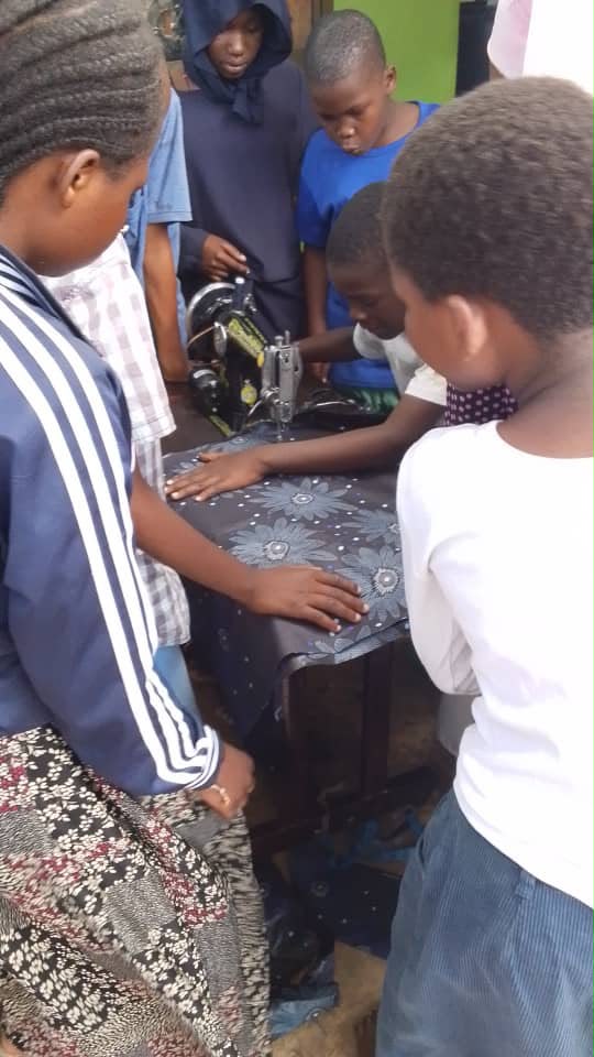 Young people learning practical sewing skills together