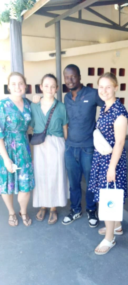 A local host and three visitors smiling together in Tanzania