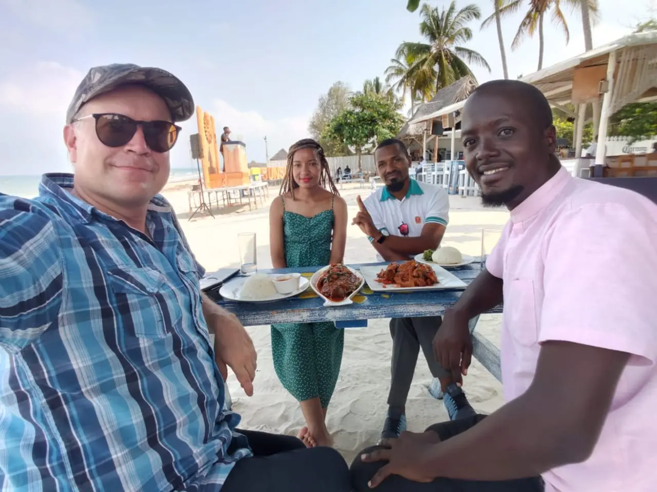 Visitors and local companions sharing a seafood meal at a beachside restaurant
