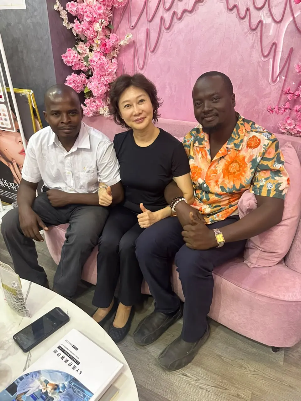 Visitors and hosts giving a thumbs up together in a lounge